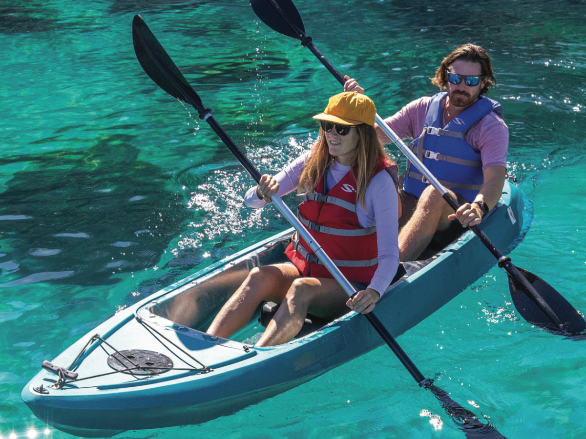 a group of people riding on the back of a boat in the water